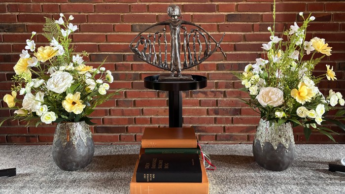 To dyrkevaser med blomster til hver side af en oldemåler