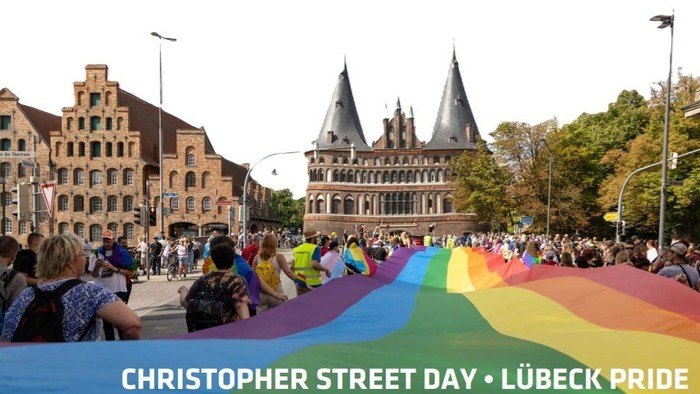 Christopher Street Day in Lübeck: farbige Fahne vor historischem Gebäude