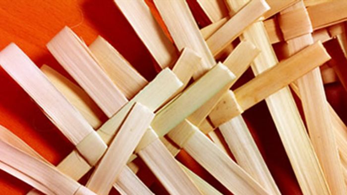 Woven wooden strips forming intricate pattern on orange background