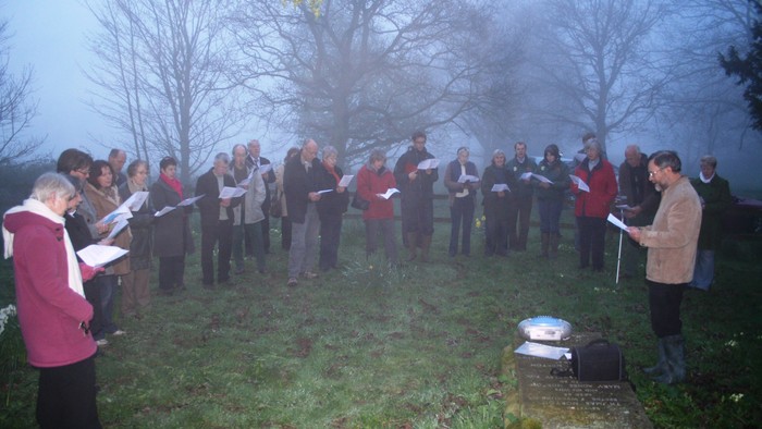 Group of people singing outdoors in a circle