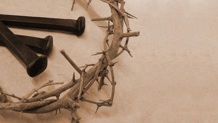 Ein Dornenkranz mit drei Nägeln darauf, in Schwarz-Weiß