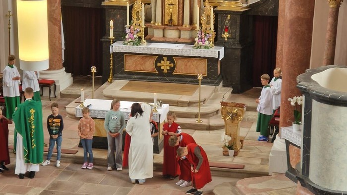 Eine religiöse Zeremonie findet statt, bei der Geistliche und Gemeinde in einer prächtigen Kirche versammelt sind.