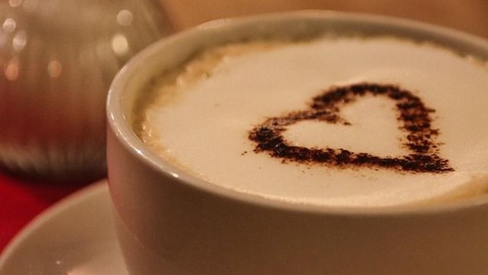 En kaffe med hjerteformet chokoladepulver på overfladen