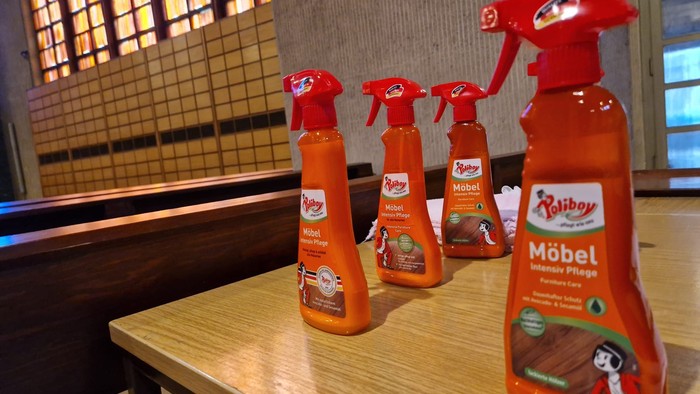 Vier Möbelreinigerflaschen auf Tisch