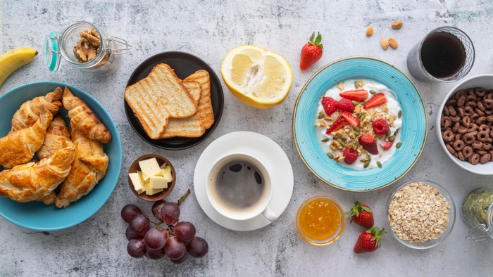 Vielseitiges Frühstücksbuffet mit Croissants, Obst, Müsli und Getränken