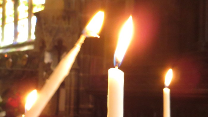 Mehrere brennende Kerzen in einer Kirche