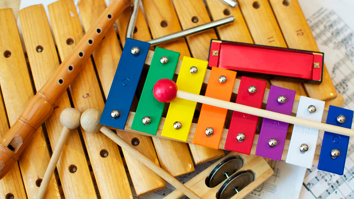 Billedet viser et udsæt af børneinstrumenter, herunder xylofon, maracas og trommer.