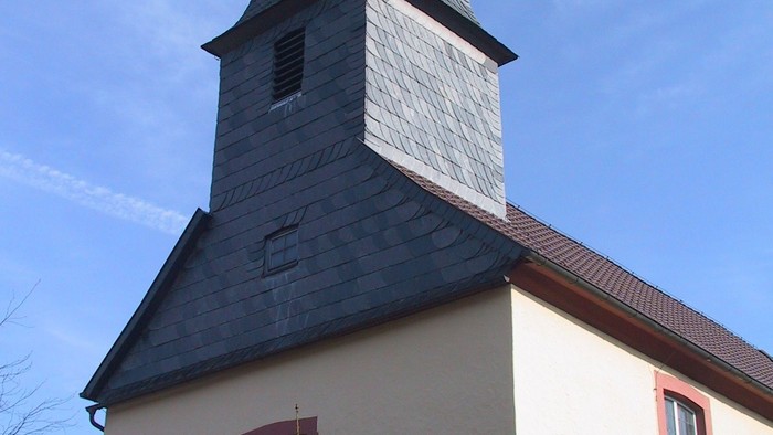 Weiße Kirche mit roter Umrandung und Uhrturm.