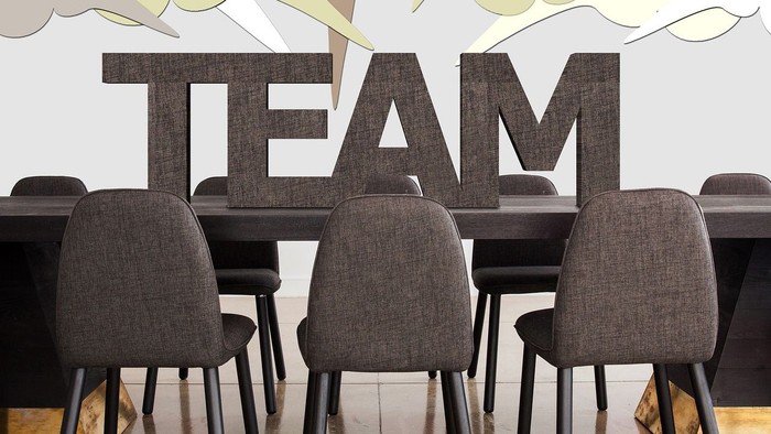 Bureau med bord og stoler, der er placeret foran et vægmaleri med ordet 