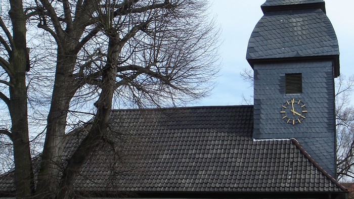 Kleine weiße Kirche mit roter Umrandung und Kirchturmspitze.