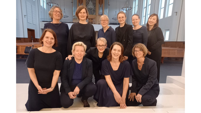 11 Sängerinnen des KLeinen Frauenchors Bilk, schwarz gekleidet in einem Kirchenraum