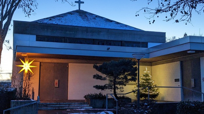 Kircheneingang mit Schnee und Weihnachtsbaum