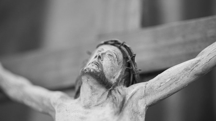 En sort-hvid statue af Jesus på korset.