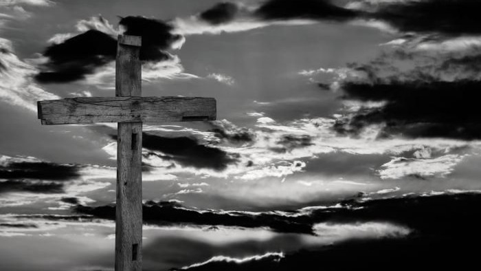 Ein hölzernes Kreuz vor einem dramatischen Wolkenhimmel