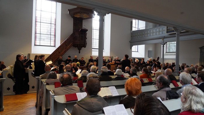 Gottesdienstbesucherinnen und Gottesdienstbesucher lauschen den Klängen von Chor und Orchester in der Neanderkirche.