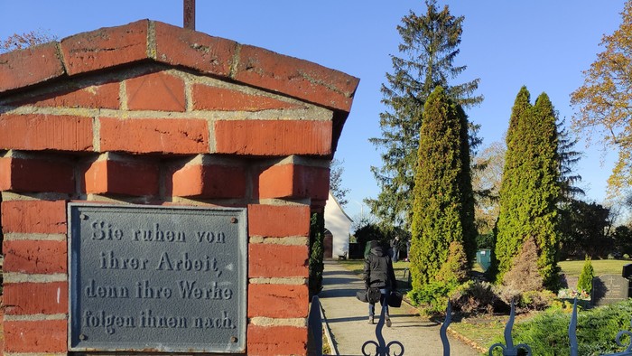 Eingang zum Friedhof in Hohenwalde. Pfeiler mit Inschrift: Sie ruhen von ihrer Arbeit, denn ihre Werke folgen ihnen nach.