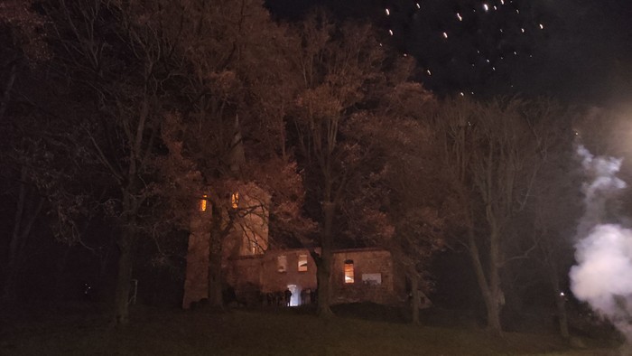 Nächtliches Feuerwerk über der beleuchteten Kirchenruine Lichtenberg.