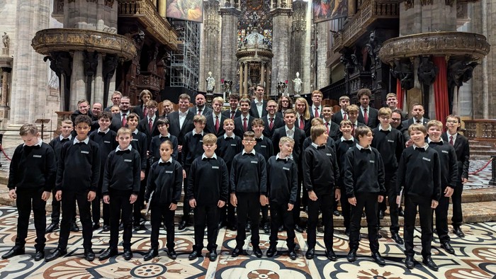 Große Gruppe von Männern in Anzügen posiert in einer Kathedrale