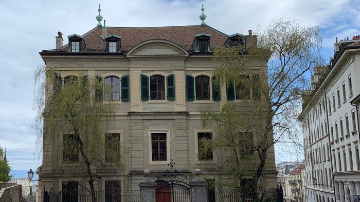 Zwei Personen gehen auf Kopfsteinpflasterstraße in historischem Viertel.