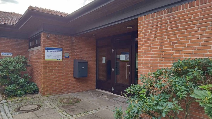 Das Bild zeigt den Eingang eines Ziegelgebäudes mit zwei Türen und einem Briefkasten.