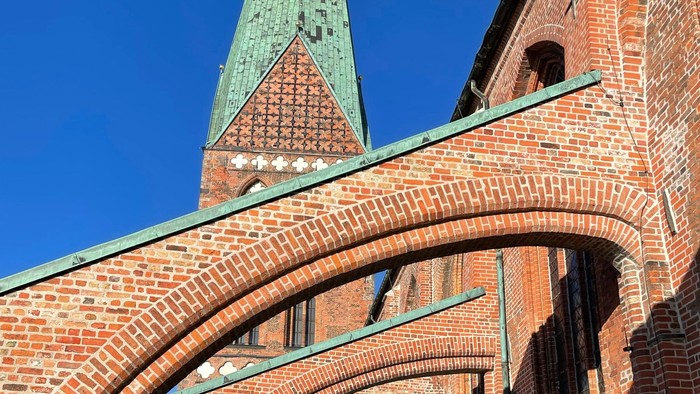 Das Bild zeigt einen Ziegelbau mit grünen Türmen und Dach.