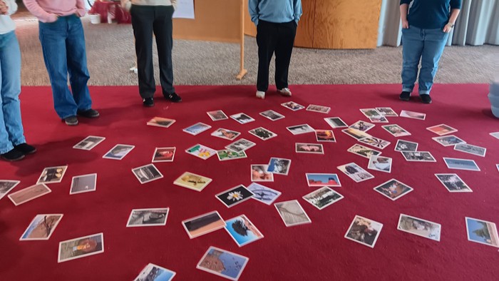 Menschen, die um verstreute Fotos auf einem roten Teppich stehen.