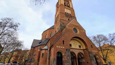 Große Ziegelkirche mit hohem Turm und Rundbogenfenster