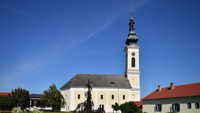 Weiße Kirche mit hohem Turm und blauen Himmel