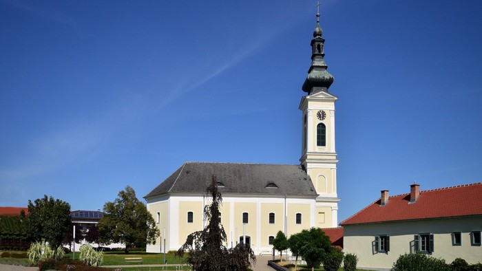 Weiße Kirche mit hohem Turm und blauen Himmel