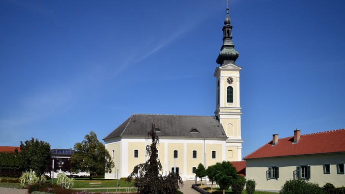 Weiße Kirche mit hohem Turm und blauen Himmel
