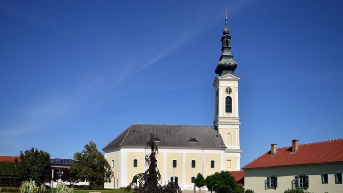 Weiße Kirche mit hohem Turm und blauen Himmel