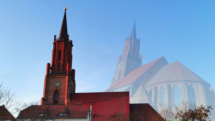 Zwei kontrastreiche Kirchen mit einem roten Backsteinturm und einer schlanken, weißen modernen Kathedrale unter klarem blauem Himmel.
