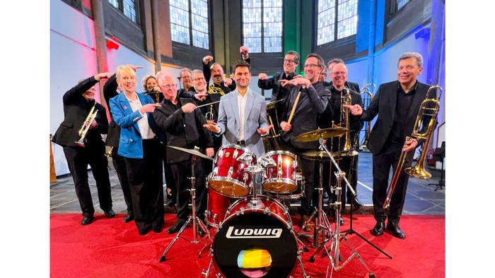 Musiker posieren mit Instrumenten in einer Kirche.