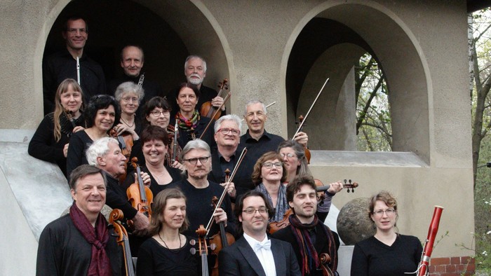 Das Schmöckwitzer Kammerorchester posiert mit seinen Instrumenten vor einem Gebäude