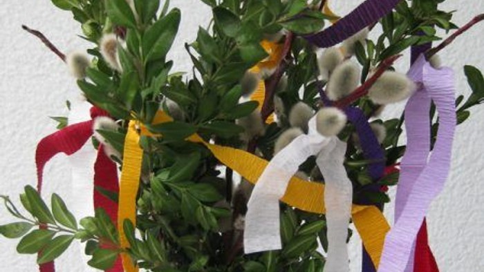 Ein Strauß grüner Blätter mit bunten Bändern