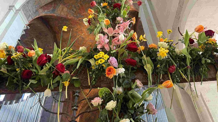 Prachtvolle Blumenarrangements in Kirche mit bunten Blumen und grünen Blättern