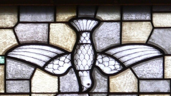 Buntes Kirchenfenster mit Kelch und Taube