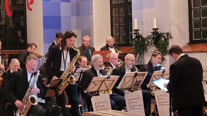 Musiker, die in einer Kirche auftreten, geleitet von einem Dirigenten.