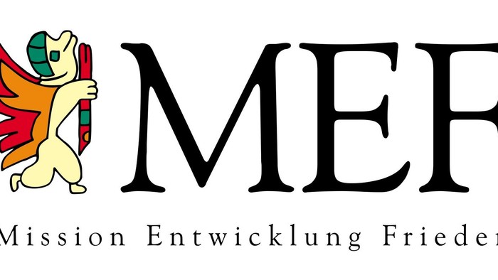 Logo für Mission Entwicklung Frieden (MEF) mit einem stilisierten Vogel und Buchstaben sowie einem missionsorientierten Slogan.