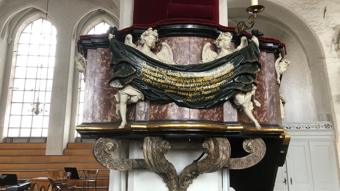 Ein prächtiger, verzierter Altar in einer Kirche mit Statuen und Inschriften.