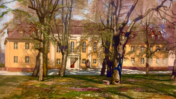 Ein charmantes historisches Gebäude, umgeben von kahlen Bäumen in einer ruhigen, parkähnlichen Umgebung.