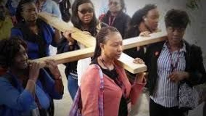 Children holding large wooden sticks in a group.