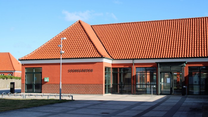 Et rødt bygning med skråt tak og store vinduer.