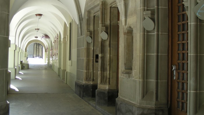 Steinerner Flur mit gewölbten Decken und Holztür