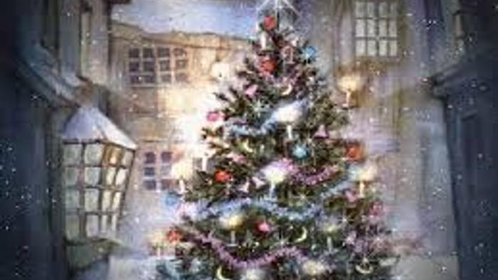 En juletree i sne for en lyst og lysende gård