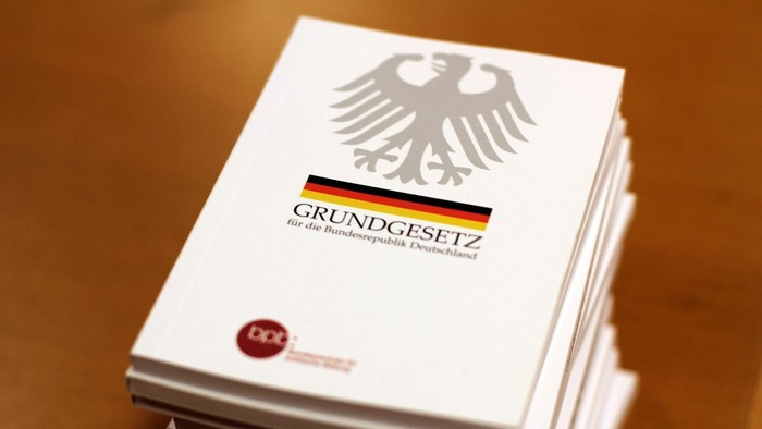 Auf einem Stapel Exemplare des Grundgesetzes