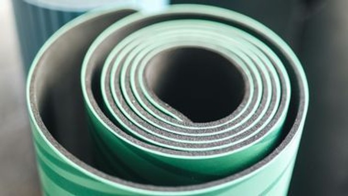 Ein aufgerolltes grünes Yoga-Mat.