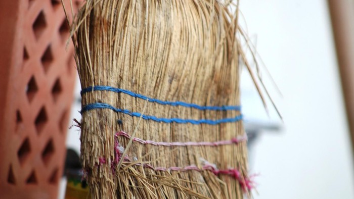 Ein Besen steht im Schnee vor einem Haus.