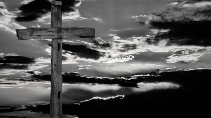 Ein hölzernes Kreuz vor einem dramatischen Wolkenhimmel