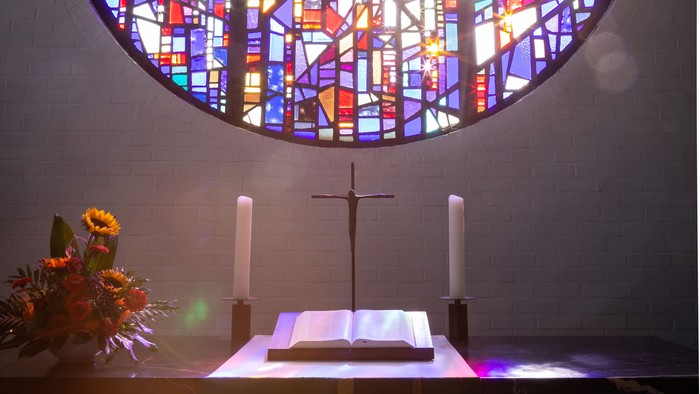 Es handelt sich um ein Buntglasfenster, das aus farbigen und bemalten Glasstücken besteht, die durch ein Gitterwerk zusammengehalten werden.